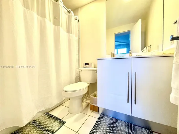 a bathroom with a toilet and a shower curtain