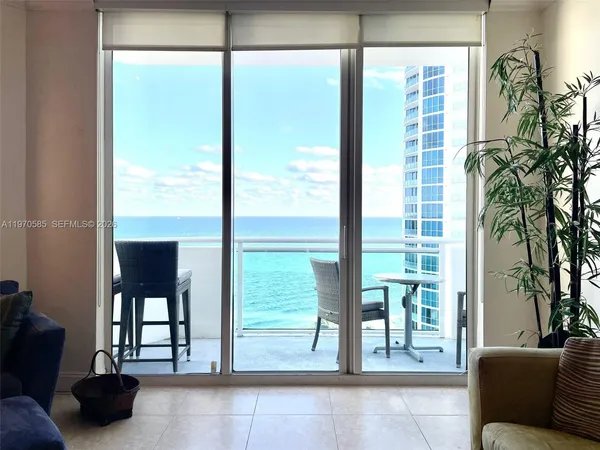 a living room with furniture and a floor to ceiling window