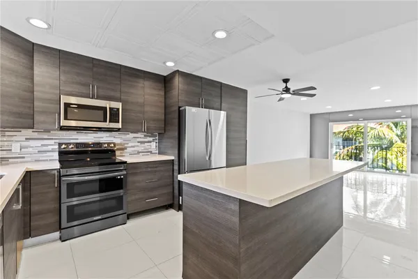 a large kitchen with stainless steel appliances a stove and refrigerator