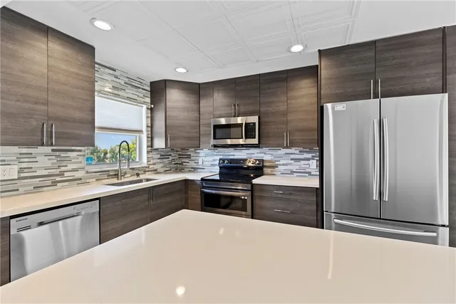 a large kitchen with cabinets stainless steel appliances and a sink