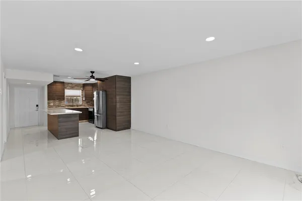 a view of a kitchen with refrigerator and chairs