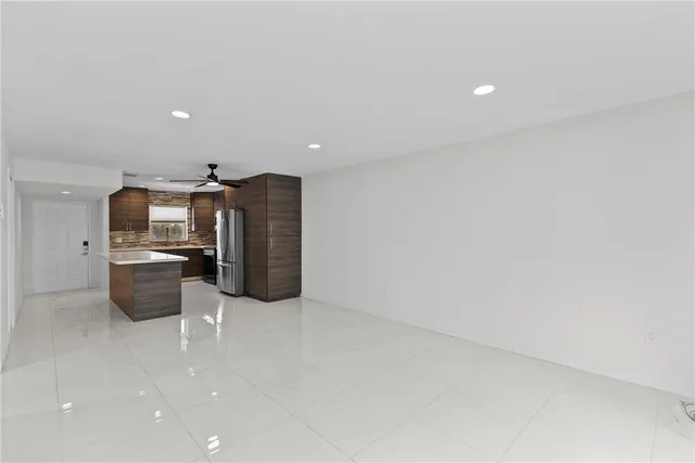a view of a kitchen with refrigerator and chairs