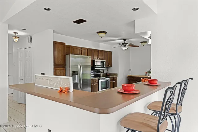 a kitchen with stainless steel appliances kitchen island granite countertop a sink dishwasher and refrigerator