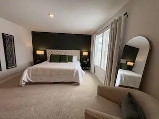 a bedroom with a bed couch and a large mirror