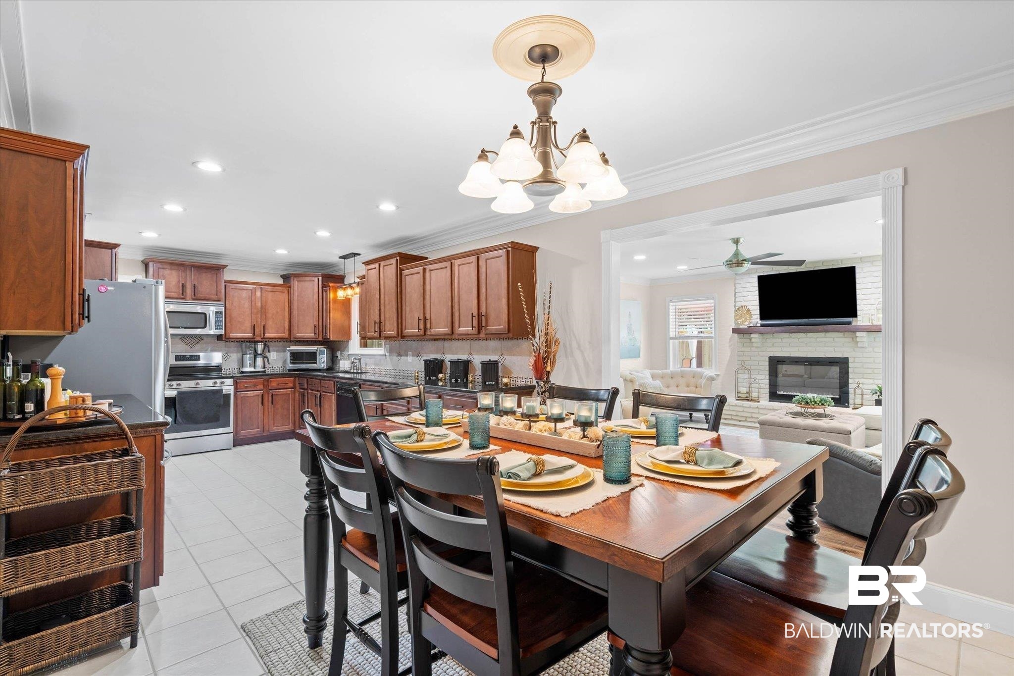 101 Ann Street Daphne, AL 36527 - Photo 14 of 38 Open-concept dining area featuring a wood-finish table with seating for six, crown molding, and an elegant chandelier