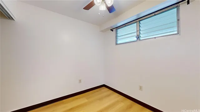an empty room with a ceiling fan and carpet