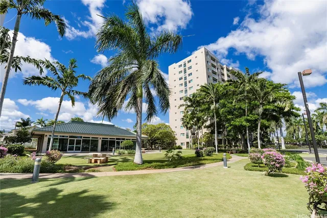 a front view of a house with garden and trees