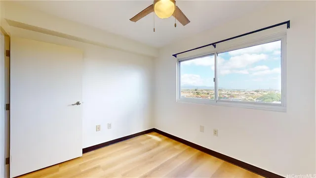 a view of a big room with wooden floor and windows