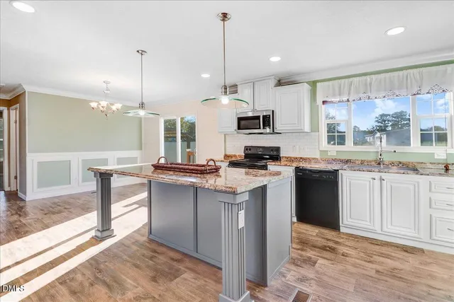 a kitchen with kitchen island granite countertop a sink counter top space appliances and cabinets
