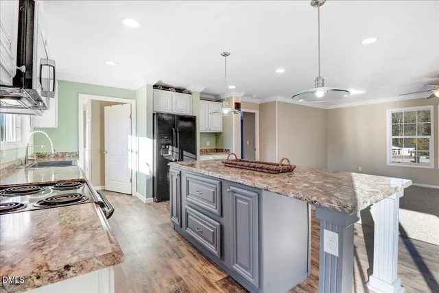 a kitchen with kitchen island granite countertop a stove and a wooden floors