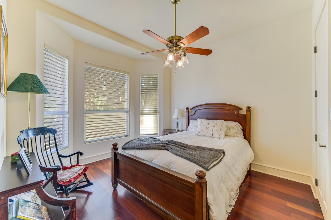 1001 Wesley Ridge Drive Spicewood, TX 78669 - Photo 18 of 35 Bedroom featuring dark wood-style flooring, multiple windows, and a ceiling fan