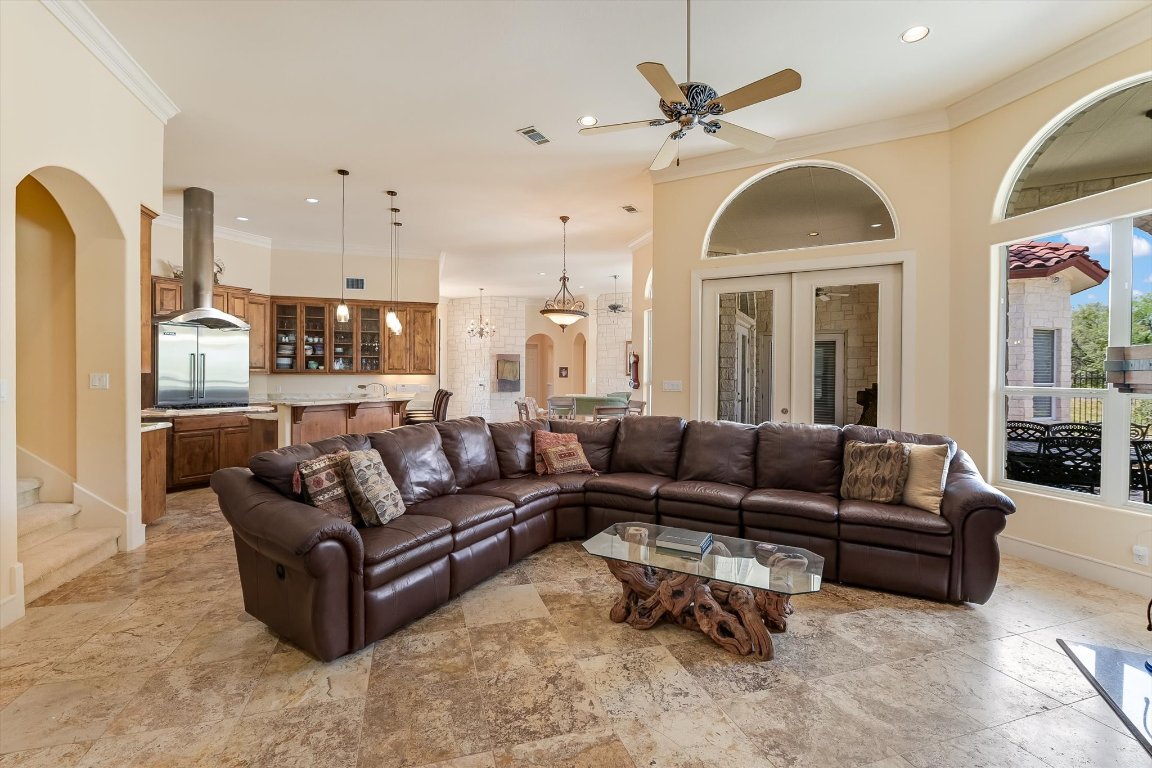 1001 Wesley Ridge Drive Spicewood, TX 78669 - Photo 4 of 35 Living area with arched walkways, crown molding, ceiling fan, recessed lighting, and stairs