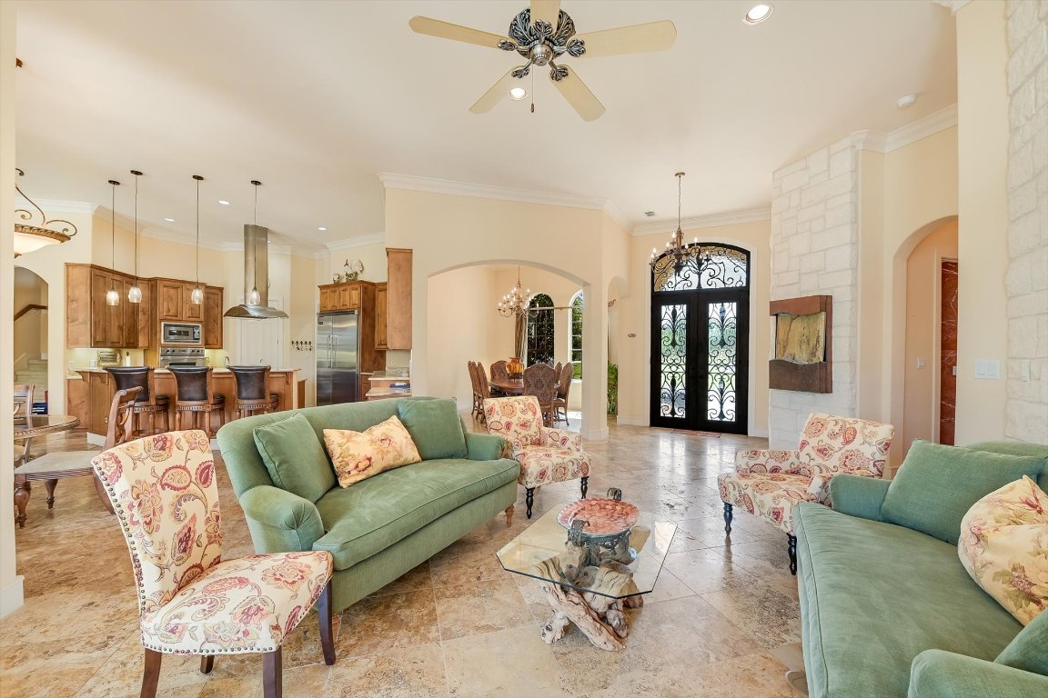 1001 Wesley Ridge Drive Spicewood, TX 78669 - Photo 7 of 35 Living room with arched walkways, a chandelier, ornamental molding, french doors, and recessed lighting
