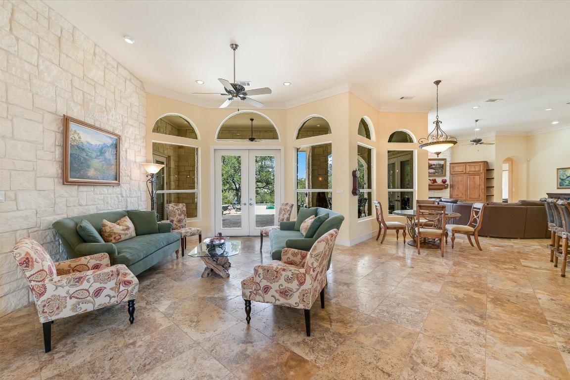 1001 Wesley Ridge Drive Spicewood, TX 78669 - Photo 8 of 35 Living room with ornamental molding, a ceiling fan, arched walkways, french doors, and recessed lighting