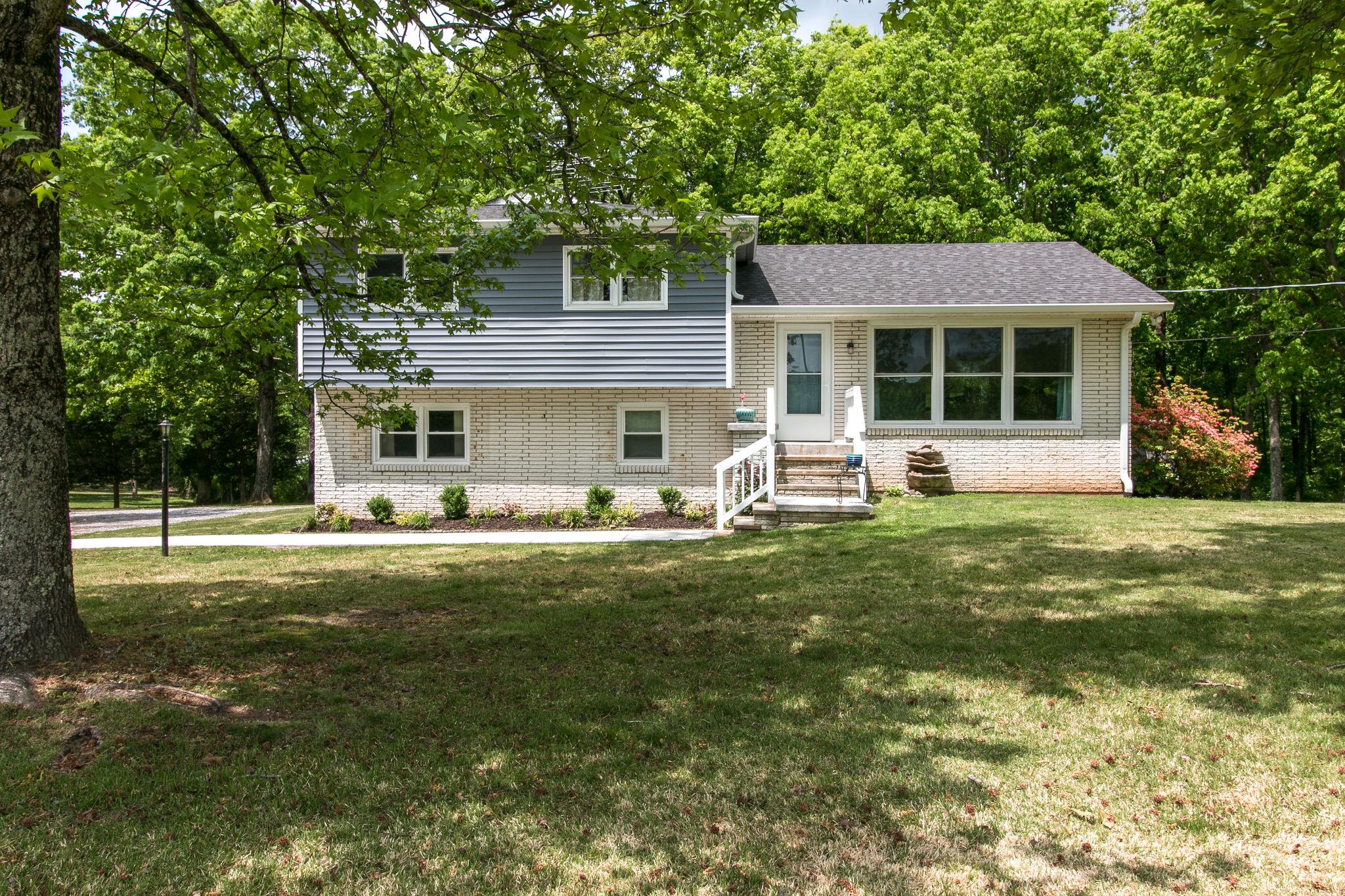 330 Cooley Ford Road Tennessee Ridge, TN 37178 - Photo 2 of 29 a front view of a house with a garden and trees