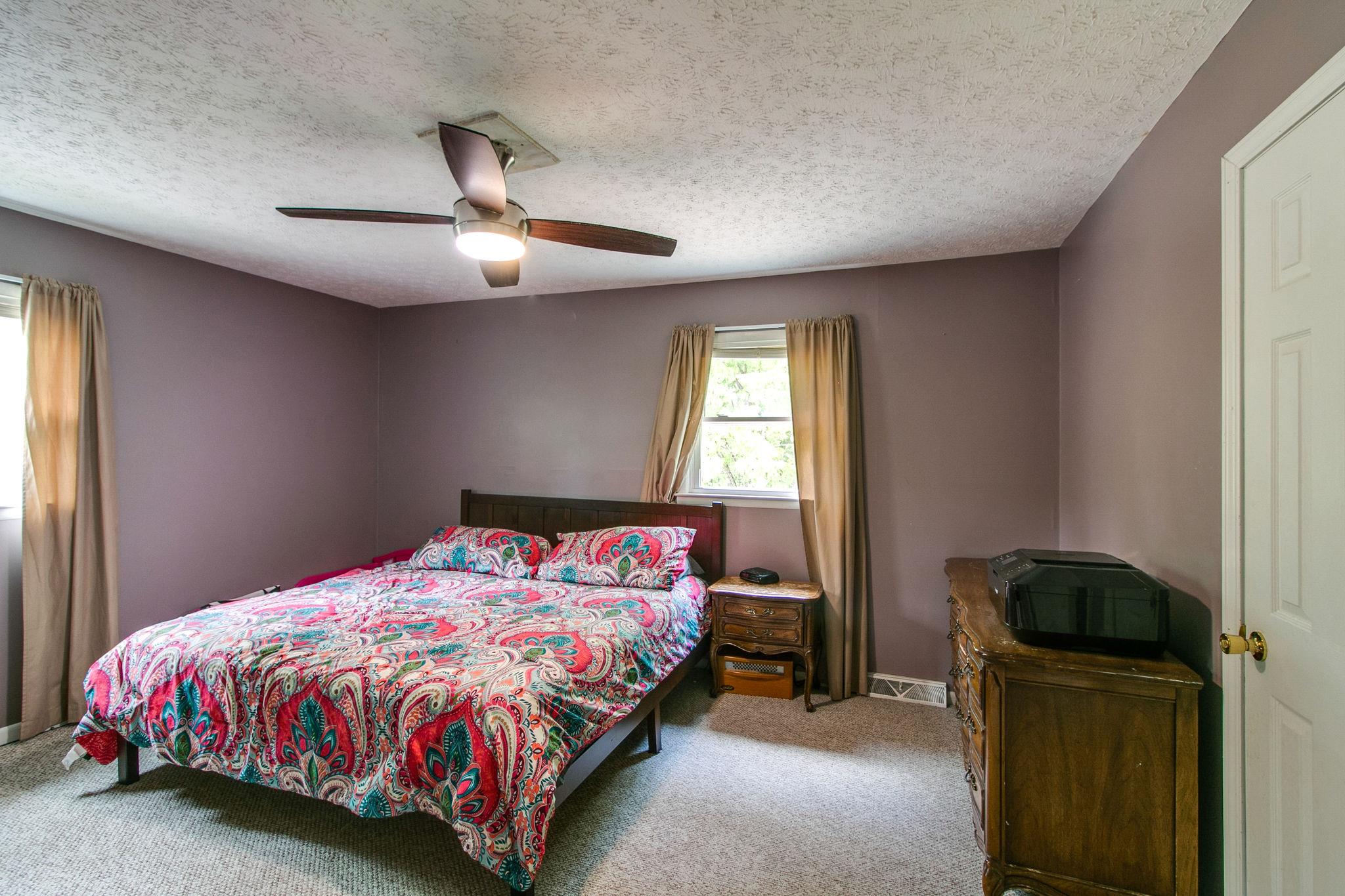 330 Cooley Ford Road Tennessee Ridge, TN 37178 - Photo 12 of 29 a bedroom with a bed and a chandelier