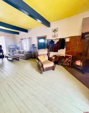 a living room with stainless steel appliances furniture a rug and a view of kitchen