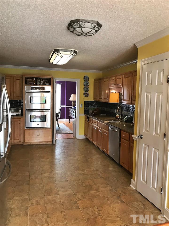 841 Pilot-Riley Road Zebulon, NC 27597 - Photo 5 of 29 a view of a kitchen with fridge and a sink