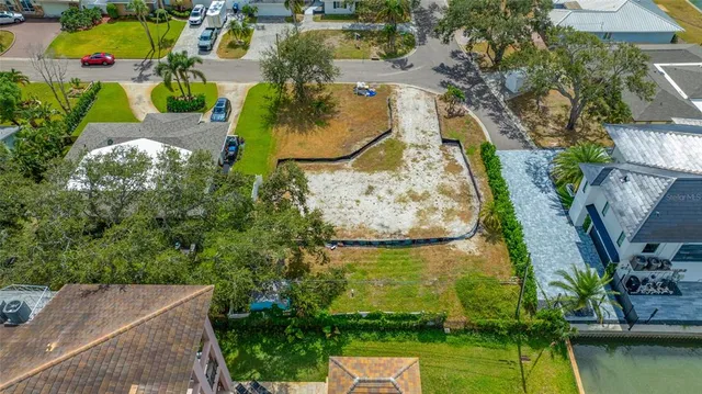 an aerial view of a house with a yard and lake view