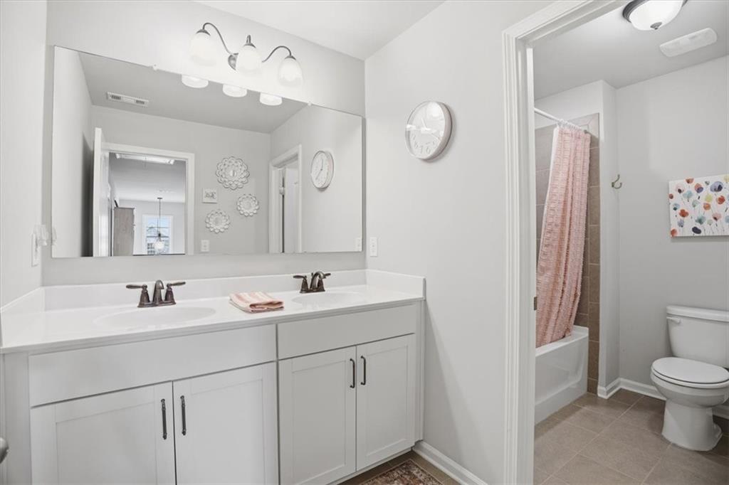 6265 Privet Way Cumming, GA 30028 - Photo 21 of 47 a bathroom with a double vanity sink mirror and toilet