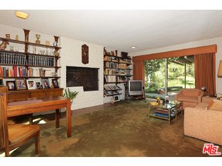12251 Castlegate Drive Los Angeles, CA 90049 - Photo 16 of 38 a living room with furniture a fireplace and a large window