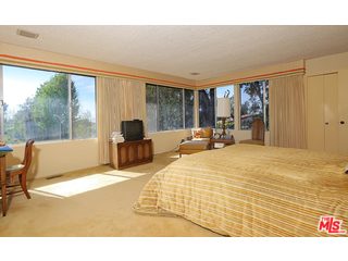 12251 Castlegate Drive Los Angeles, CA 90049 - Photo 18 of 38 a bed sitting in a spacious bedroom next to a window