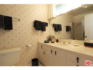 12251 Castlegate Drive Los Angeles, CA 90049 - Photo 28 of 38 a bathroom with a sink a large mirror and a toilet