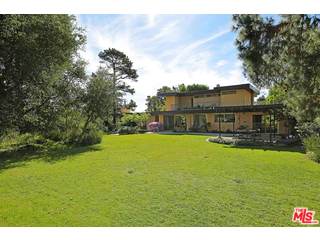 12251 Castlegate Drive Los Angeles, CA 90049 - Photo 29 of 38 a view of a large pool with lawn chairs under an umbrella