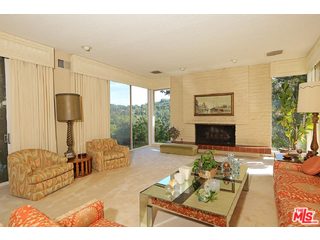 12251 Castlegate Drive Los Angeles, CA 90049 - Photo 7 of 38 a living room with furniture large window and a fireplace