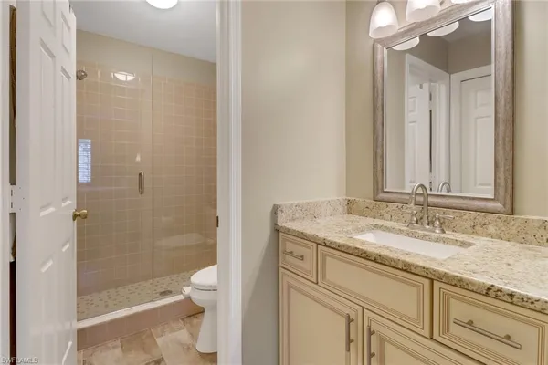 a bathroom with a granite countertop sink toilet and shower
