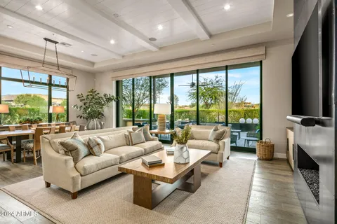 a living room with furniture a flat screen tv and a floor to ceiling window