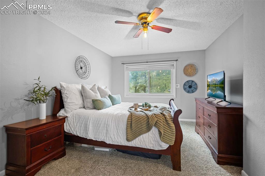 8228 Highway 24 Cascade, CO 80809 - Photo 9 of 36 a bedroom with a bed and a chandelier