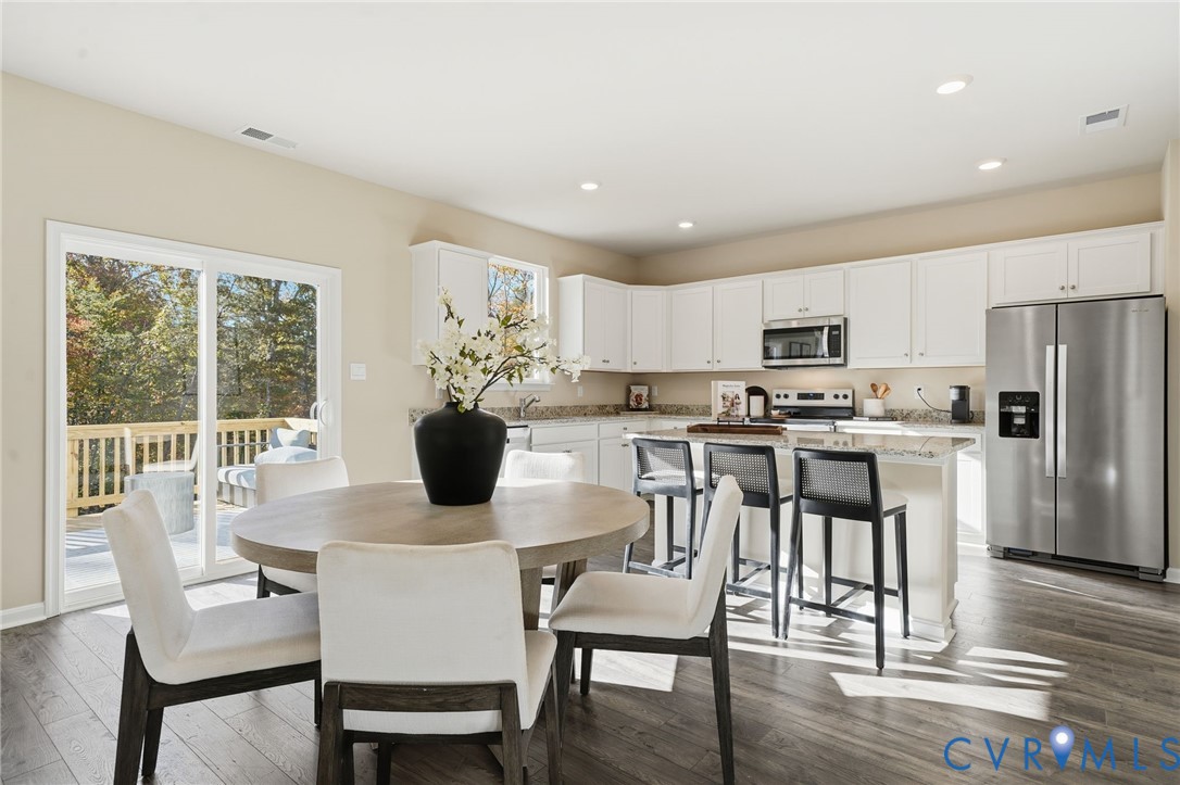 6338 Sterling Way Ruther Glen, VA 22546 - Photo 26 of 47 a kitchen with a table chairs refrigerator and microwave