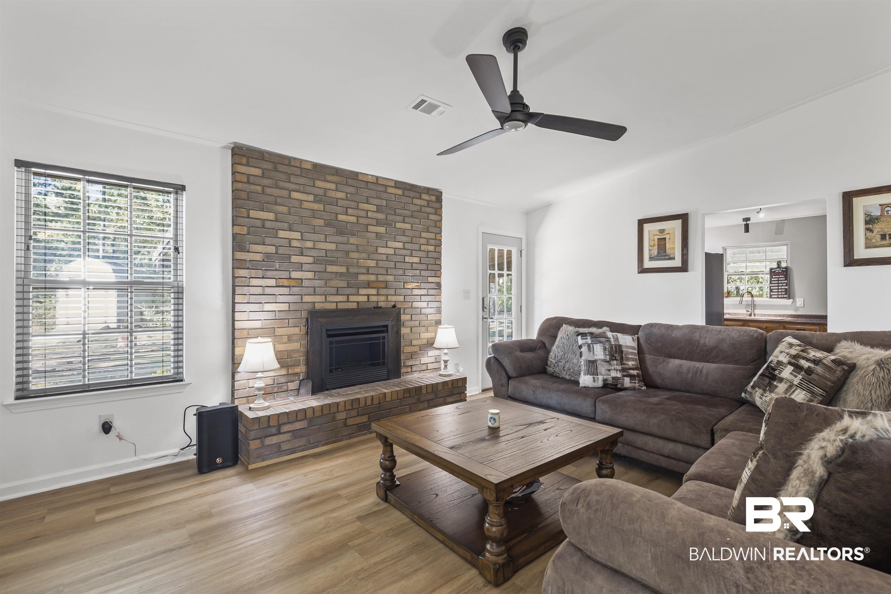 8911 Owassa Road Evergreen, AL 36401 - Photo 7 of 24 Living room with a brick fireplace, wood finished floors, and a ceiling fan