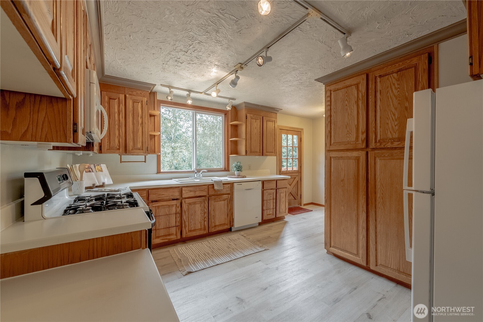 20006 68th Avenue Northeast Kenmore, WA 98028 - Photo 12 of 40 a kitchen with a refrigerator a sink and wooden cabinets