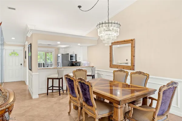 a view of a dining room with furniture a chandelier and wooden floor