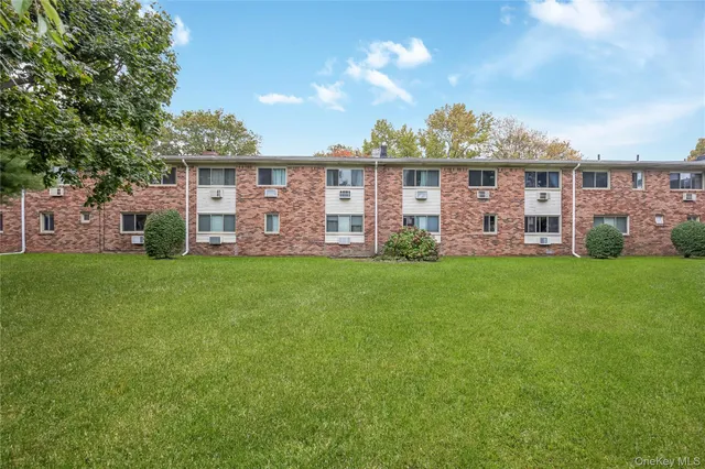 a front view of a house with a yard and potted plants