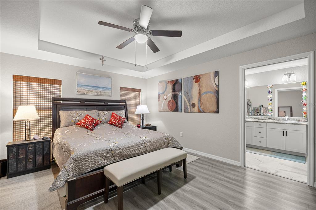 9239 Southwest 197th Circle Dunnellon, FL 34432 - Photo 22 of 57 a bedroom with a large bed a chandelier and dresser