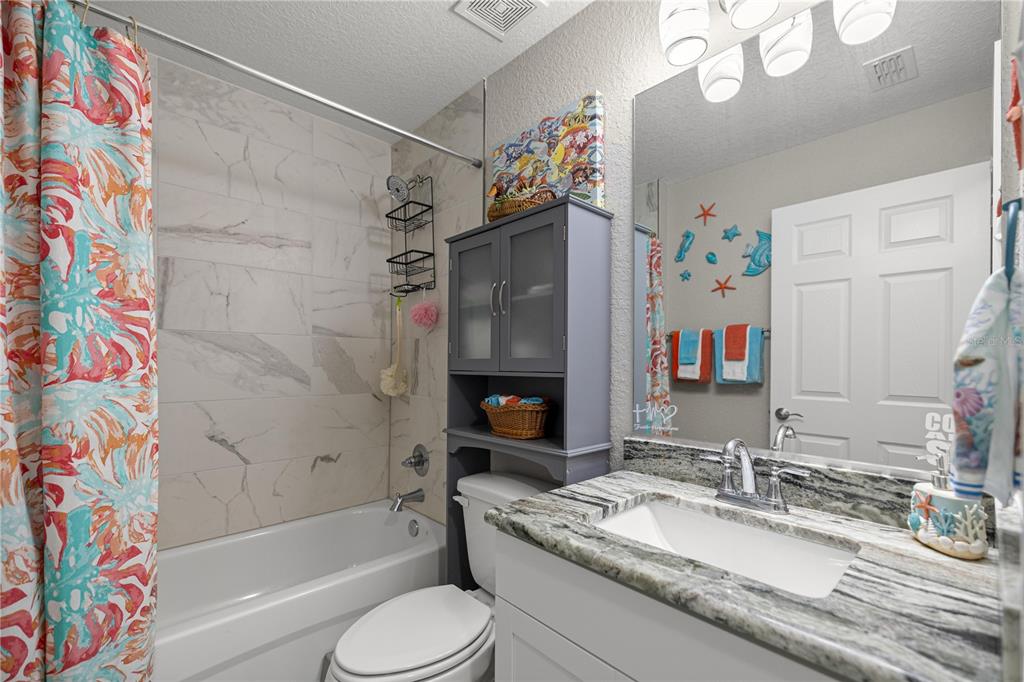 9239 Southwest 197th Circle Dunnellon, FL 34432 - Photo 26 of 57 a bathroom with a granite countertop bathtub sink vanity mirror and toilet