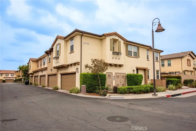 a view of a white house with a street next to a road