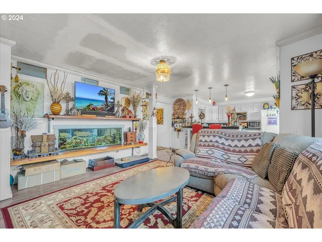 a kitchen with stainless steel appliances kitchen island granite countertop a table chairs and a wooden floors