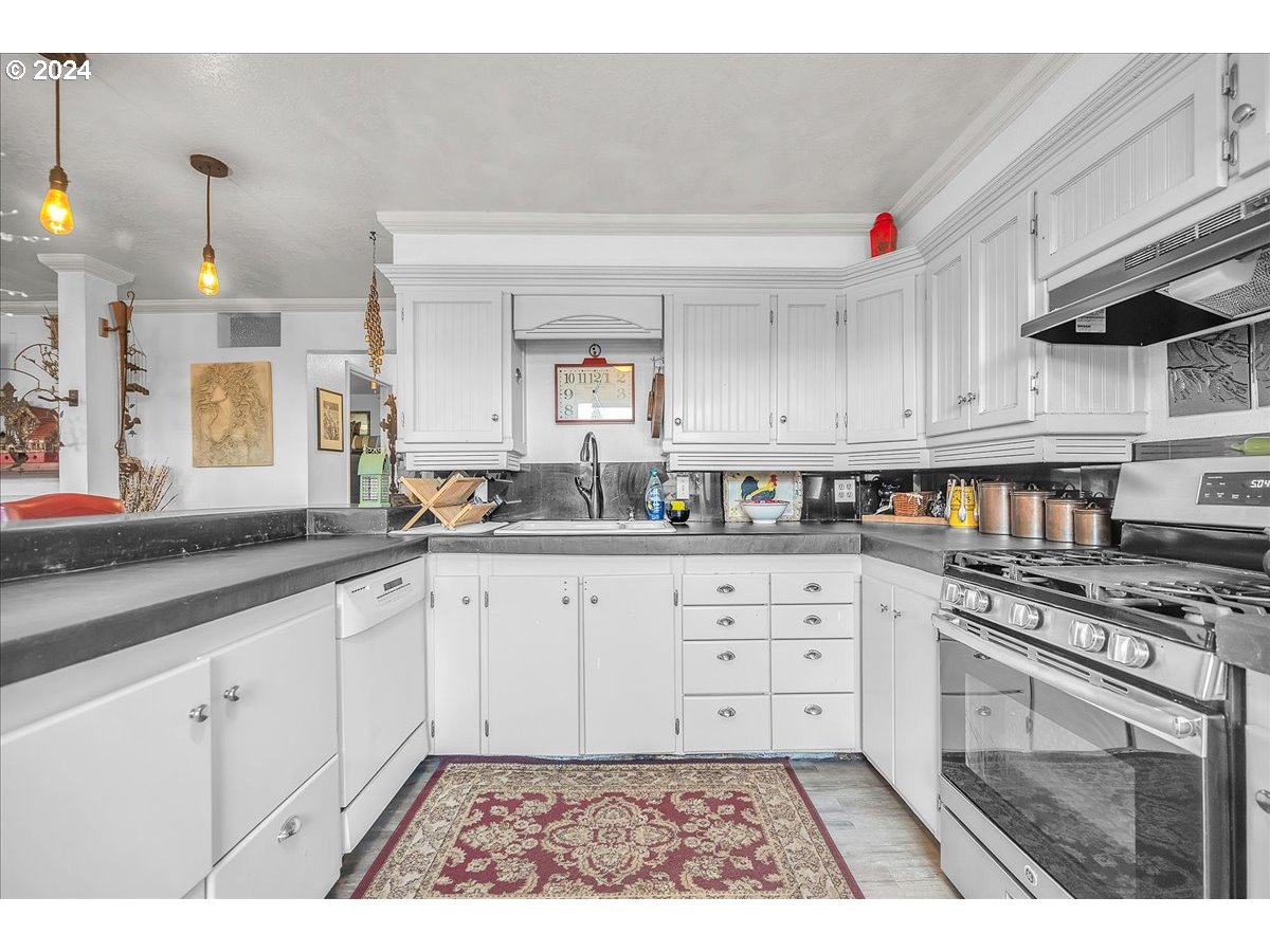 26901 Northwest St Helens Road Scappoose, OR 97056 - Photo 32 of 43 a kitchen with granite countertop a stove a sink and a white cabinets