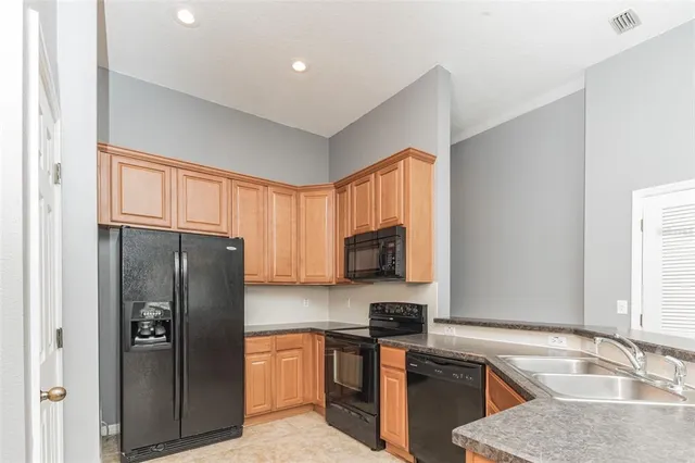 a kitchen with stainless steel appliances granite countertop a refrigerator stove and sink