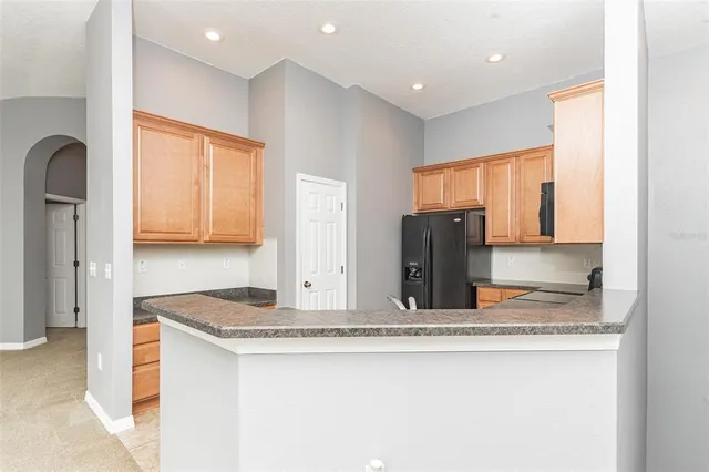 a kitchen with stainless steel appliances granite countertop a sink and a refrigerator