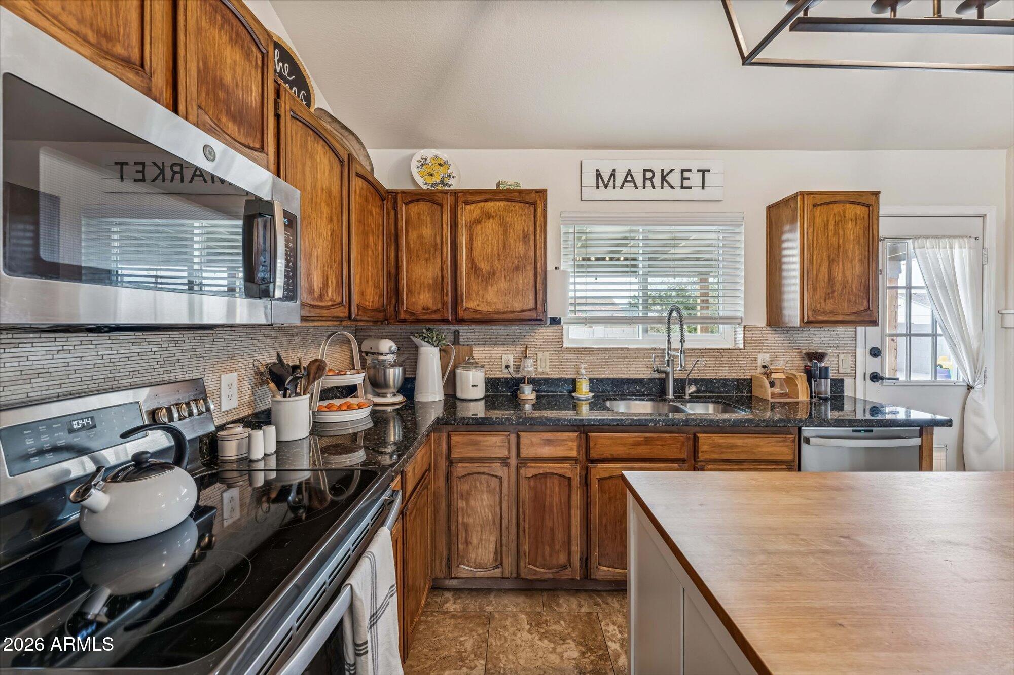 2019 East Butler Street Chandler, AZ 85225 - Photo 15 of 27 a kitchen with stainless steel appliances granite countertop a sink stove and cabinets