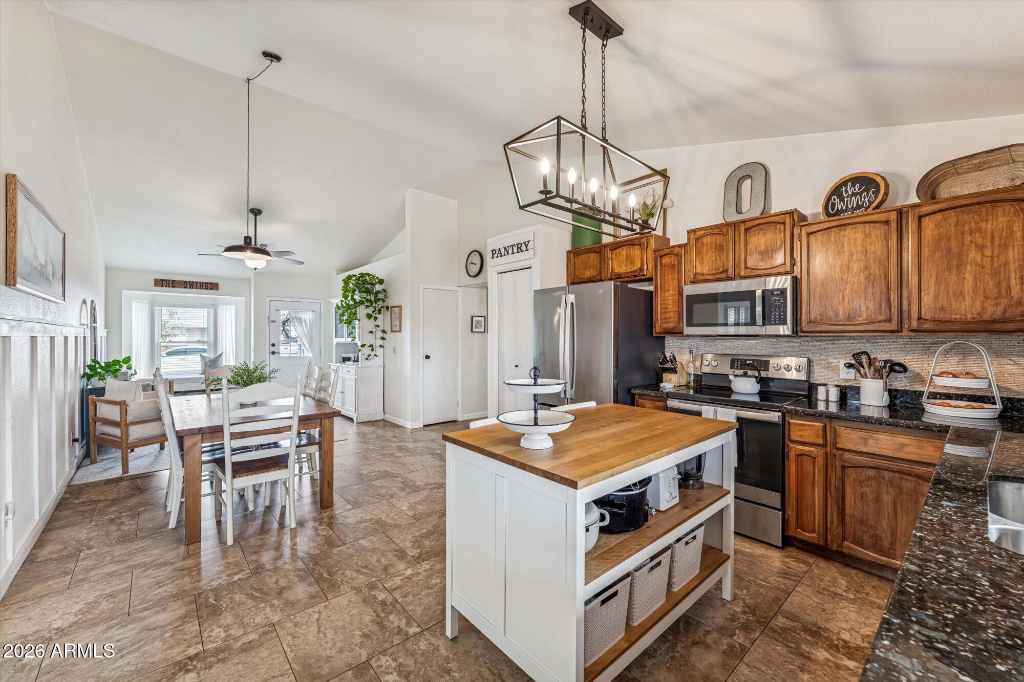 2019 East Butler Street Chandler, AZ 85225 - Photo 16 of 27 a open kitchen with stainless steel appliances granite countertop a stove oven a kitchen island a dining table and chairs