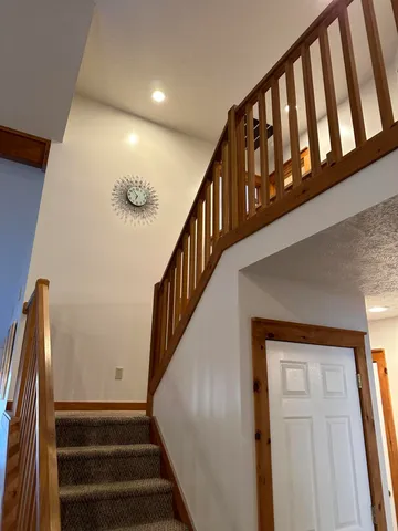 a view of staircase with lots of frames on wall and a window