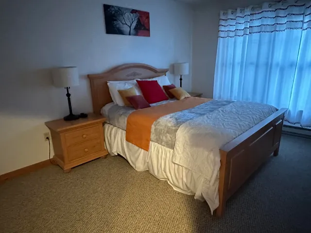 a bed sitting in a bedroom next to a wooden walls