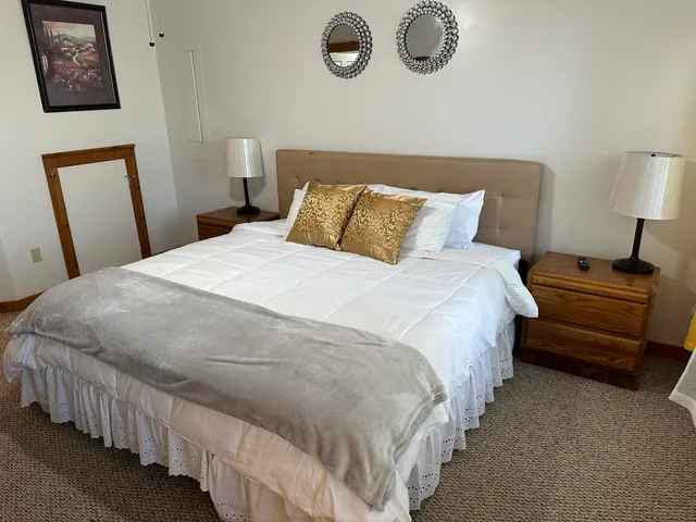 a bedroom with a bed and a lamp on table