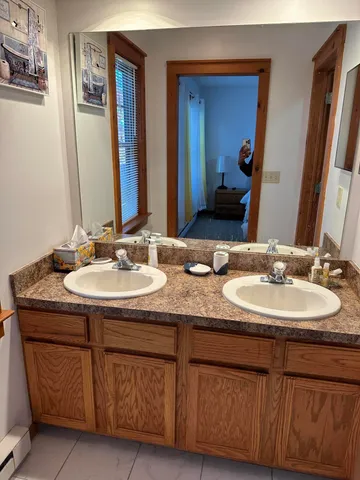 a bathroom with double sink and a mirror